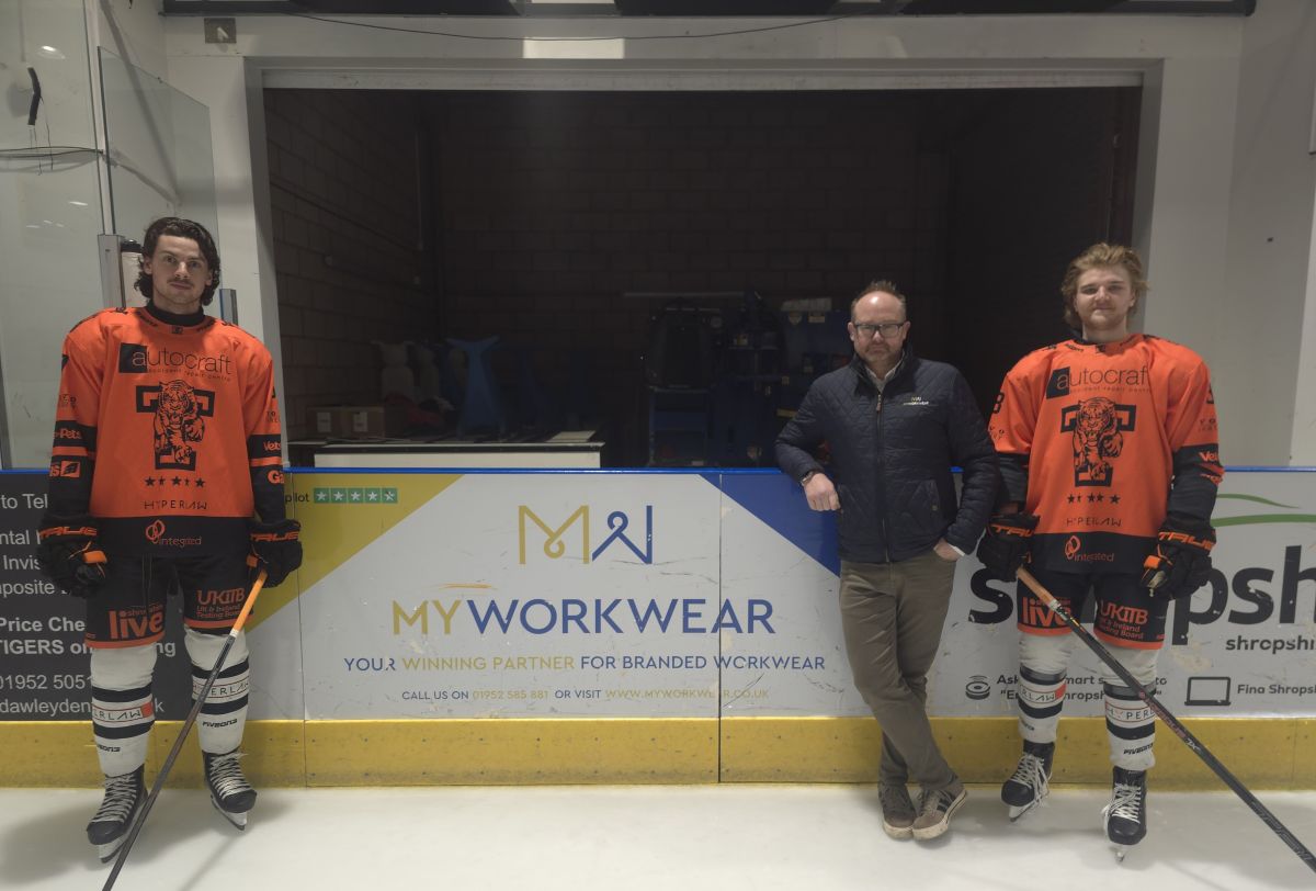 MyWorkwear Co Owner James Worthington pictured with Telford Tigers players next to their rinkside board